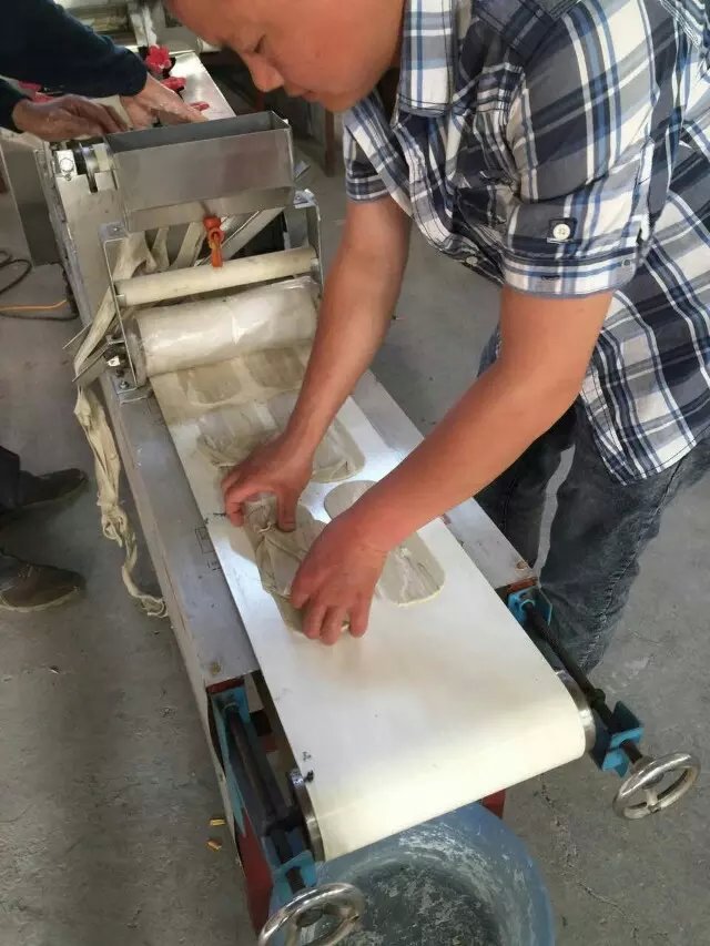 工作人員和王先生在車間進(jìn)行機器調(diào)試