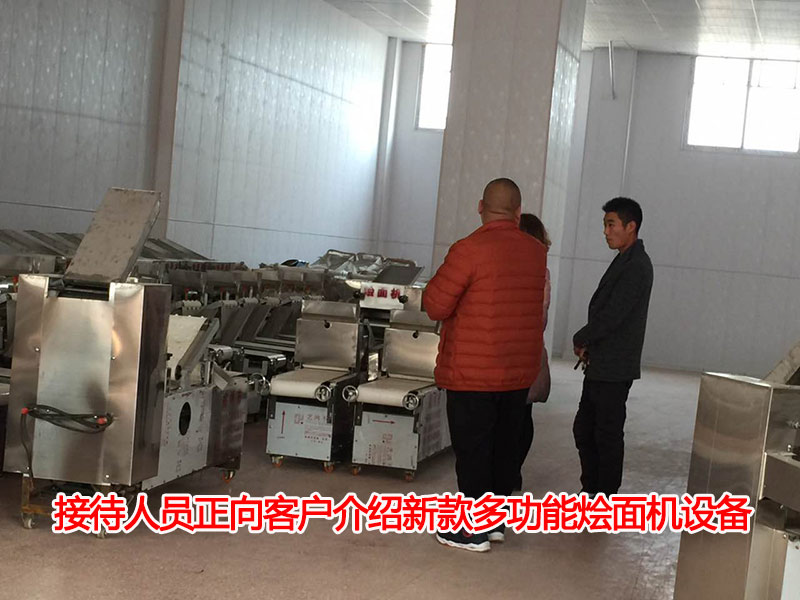 接待人員正向客戶介紹新款多功能燴面機設(shè)備